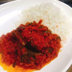 A picture of Palm oil stew and boiled rice.