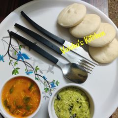 A picture of Sambar with idli and coconut chutney.