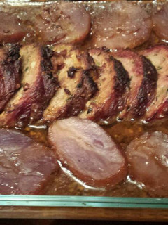 Una foto de Redondo de cerdo ibérico relleno de piña, piñones y foie con salsa y patatas moradas
