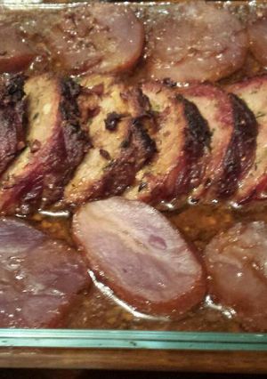 Una foto de Redondo de cerdo ibérico relleno de piña, piñones y foie con salsa y patatas moradas