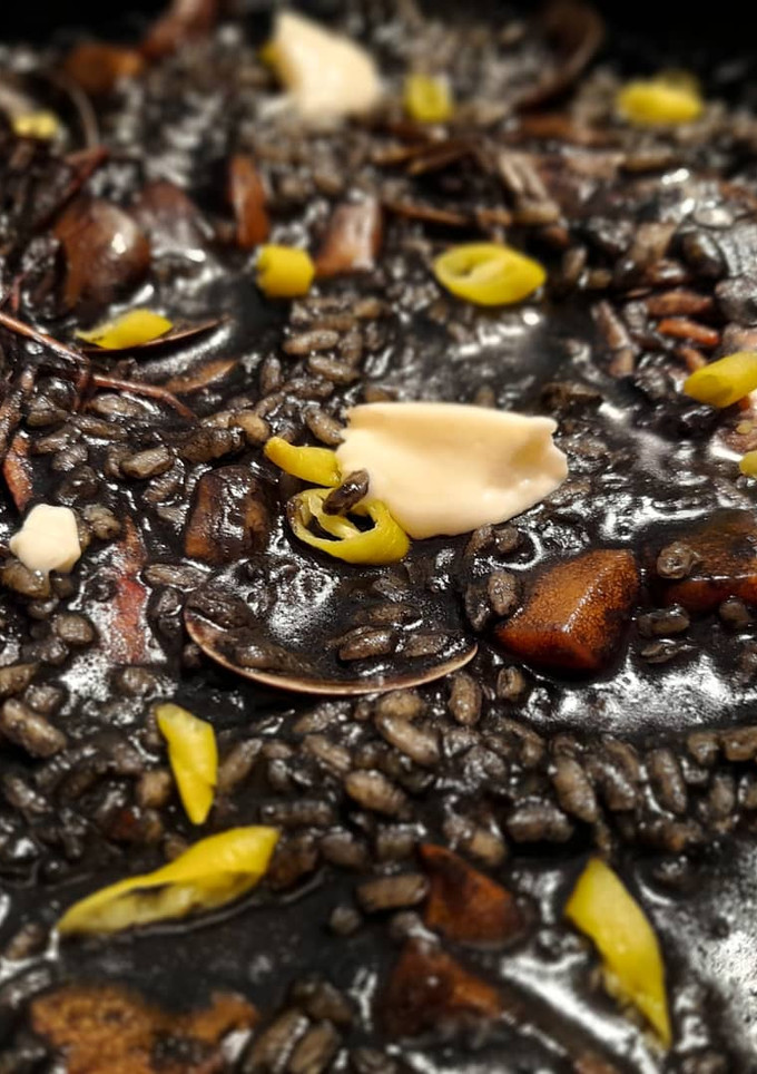 Una foto de Arroz negro caldoso de sepia y gambas