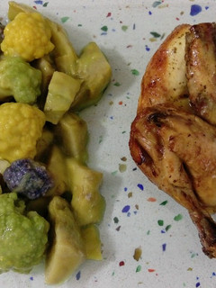 Una foto de Picantón asado con salteado de alcachofas y mini coliflores de colores
