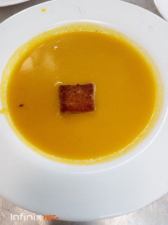 A picture of Carrot soup and croûton.