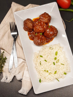 A picture of Meatballs in tomato and red wine sauce.