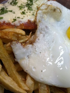 Una foto de Milanesas a la napolitana con papas fritas y huevos fritos