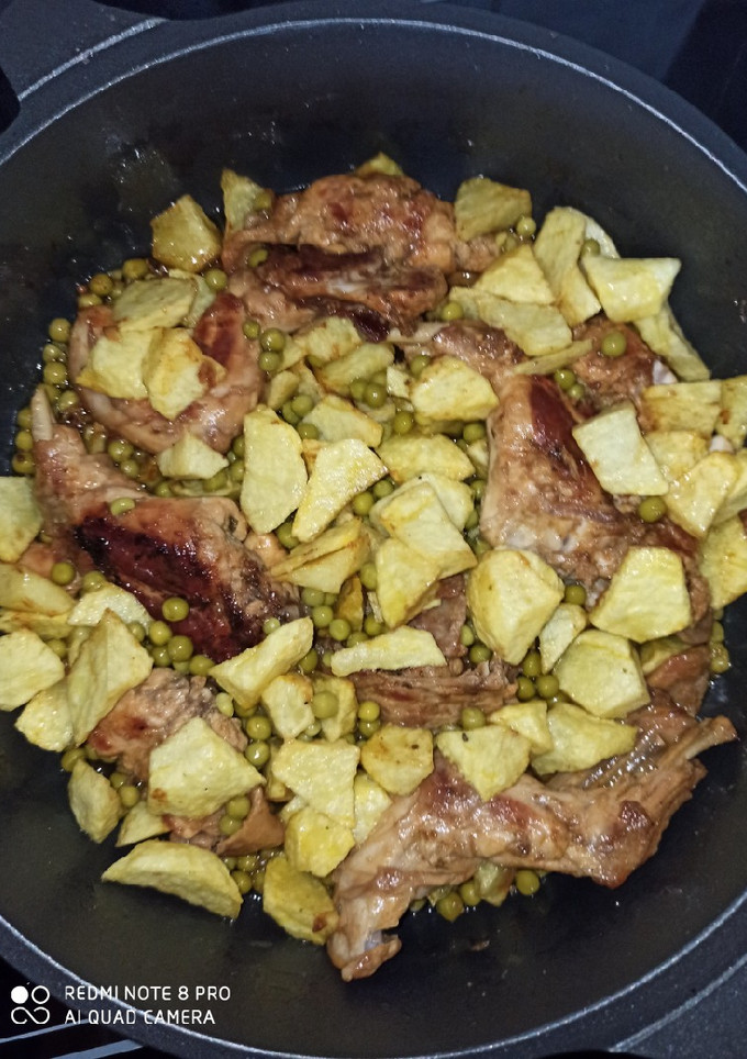Una foto de Conejo al ajillo con patatas y guisantes