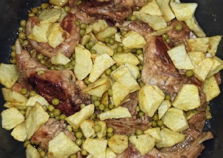 Conejo al ajillo con patatas y guisantes