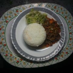 A picture of Plain rice with green grams and steamed cabbage.