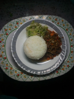 A picture of Plain rice with green grams and steamed cabbage.