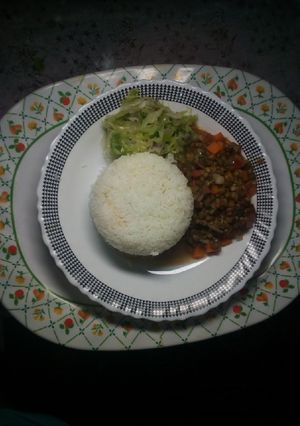 A picture of Plain rice with green grams and steamed cabbage.