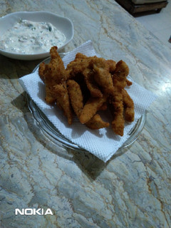 A picture of Chicken Fingers with creamy sauce.