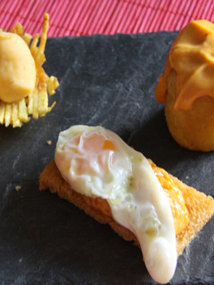 Una foto de Timbal de patata relleno de espuma de farinato, tosta de pan crujiente con cordón de crema de farinato y huevo de codorniz y nido de patata con parmentier de farinato