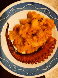 Una foto de Pulpo asado con cama de cebolla y patatas al pimentón de La Vera