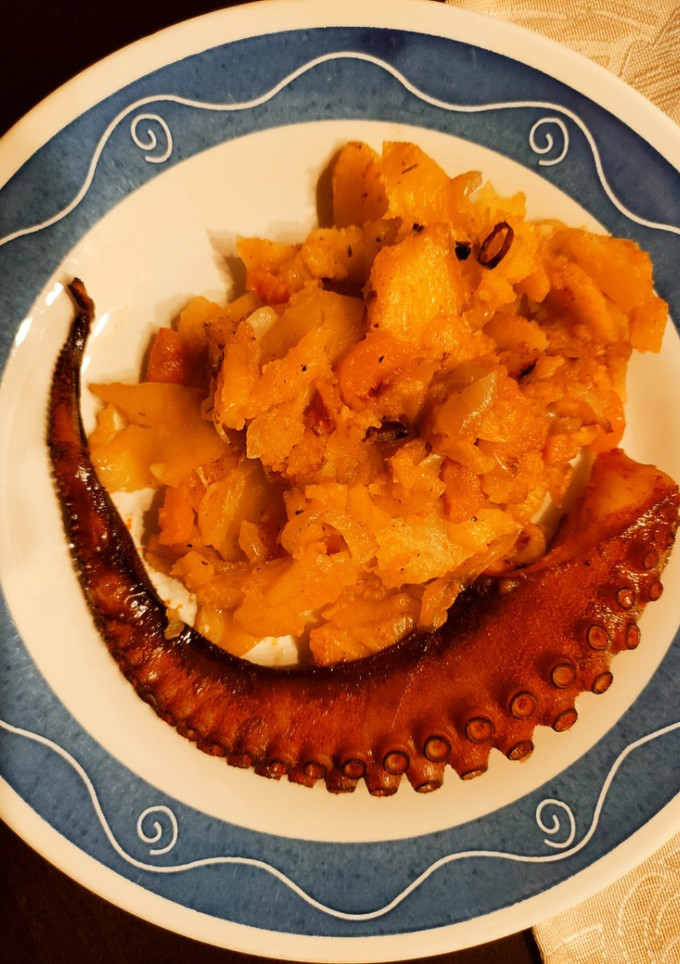 Una foto de Pulpo asado con cama de cebolla y patatas al pimentón de La Vera