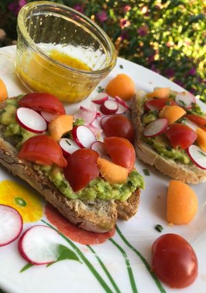 Une photo de Tartine à l’avocat avec radis, melon et tomates cerise