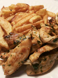 Una foto de Tiras de pechugas de pollo marinadas con patatas fritas