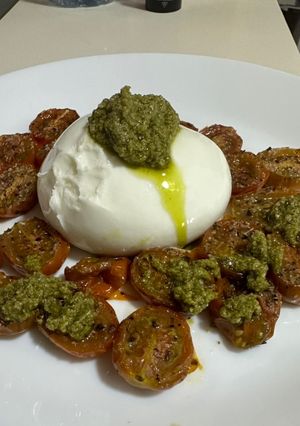 Una foto de Burruta con tomates cherry asados y Pesto