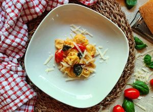 Foto di Tortellini al prosciutto crudo con pomodorini, basilico e grana