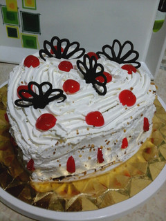 Una foto de Tarta corazón de chocolate con crema pastelera y nata