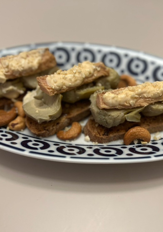 Una foto de Tostas de melva, alcachofa y virutas de anacardo