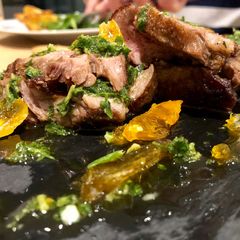 A picture of Iberico Pork Pluma with shards of salt cured egg yolk and smoked chimmi churri sauce.