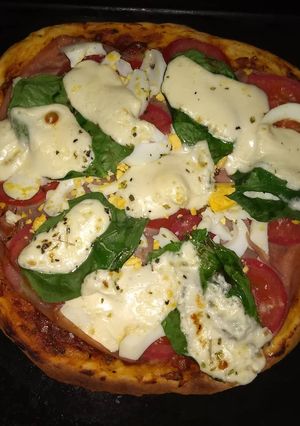 Una foto de Pizza casera con hojas de espinacas 🥚🧀🍅