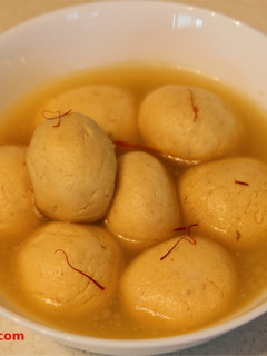 A picture of Kesar Rasgulla / Saffron Cottage Cheese Balls In Sugar Syrup.