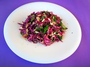 Una foto de ensalada con espinacas , col morada