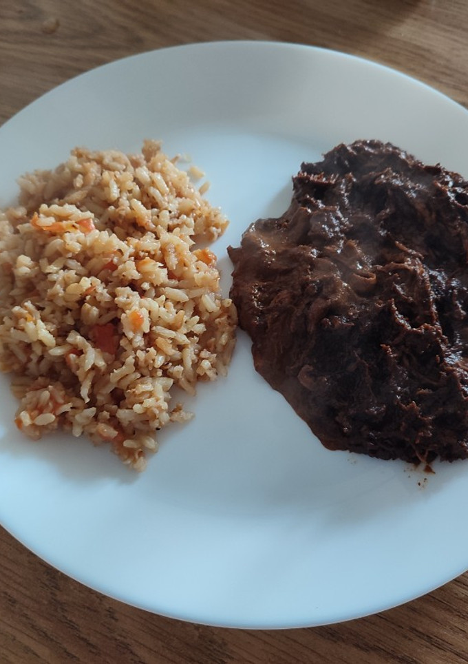 Una foto de Pollo con Mole y arroz rojo