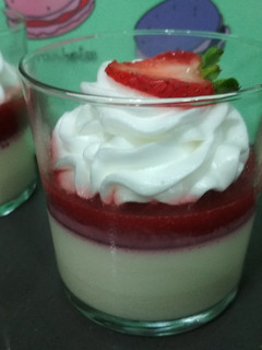 Una foto de Panna cotta con fresa en vasito