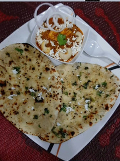 A picture of Paneer Butter Masala with Naan.