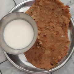 A picture of Aloo pratha with curd.