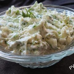A picture of Tzatziki dip with cucumber.