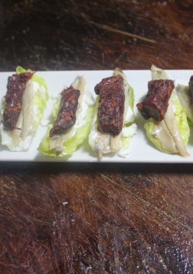 Una foto de Hojas de lechuga con morcilla y boquerones