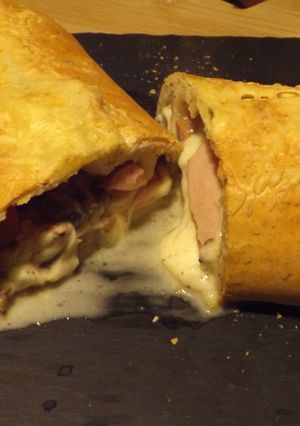Una foto de Rollo relleno de salchichas, quesos y salsa de champiñones