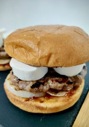 Una foto de Burger de Butifarra de Cebolla Caramelizada con Queso de Cabra y Mermelada de Pétalos de Rosa