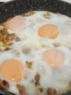 Una foto de Huevos estrellados con champiñones al ajillo picantes