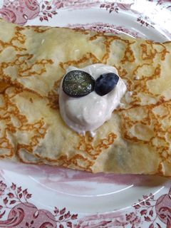 Una foto de Crêpes rellenas de fruta, crema de requesón, yogurt griego con sirope de agave y canela