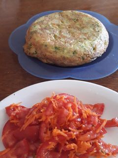 Una foto de Tortilla de papas con ensalada fresca de tomate, zanahoria y mix