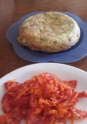 Una foto de Tortilla de papas con ensalada fresca de tomate, zanahoria y mix