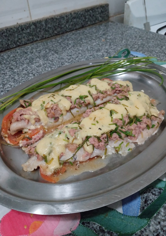 Una foto de Merluza al atún y queso azul, sobre base de tomates al tomillo