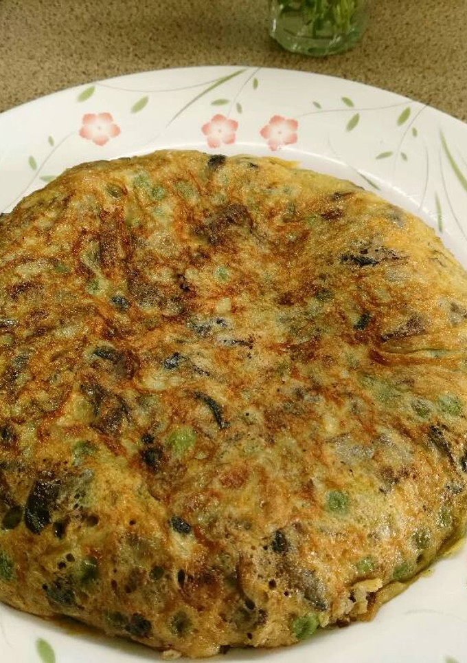 Una foto de Tortilla de setas con guisantes y ajos tiernos