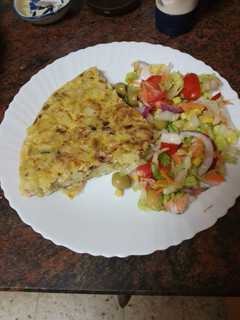 Una foto de Tortilla de papas con cebolla y puerro sofrito y ensalada