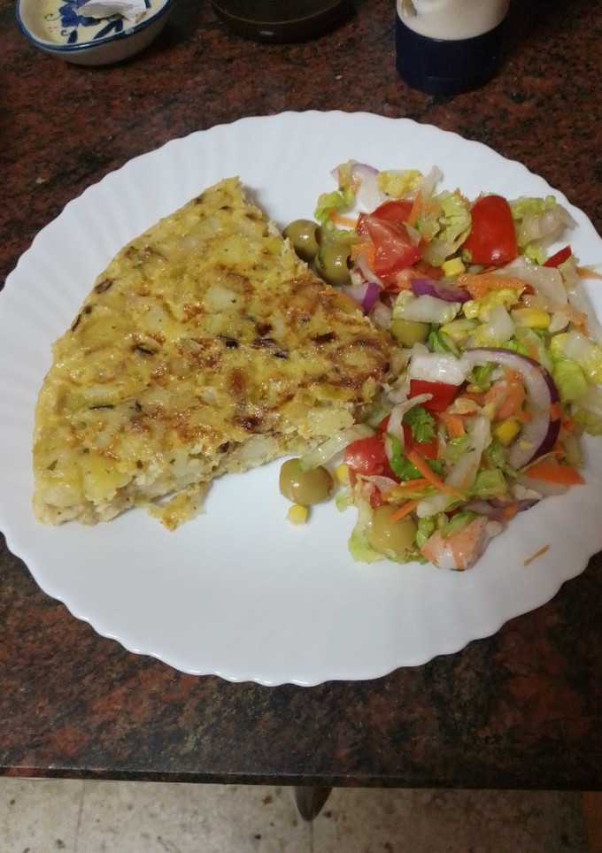 Una foto de Tortilla de papas con cebolla y puerro sofrito y ensalada