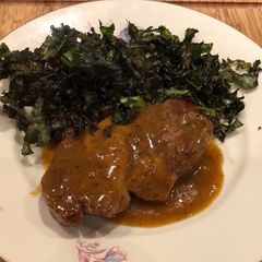 A picture of Greek braised pork with beer, mustard and orange sauce.
