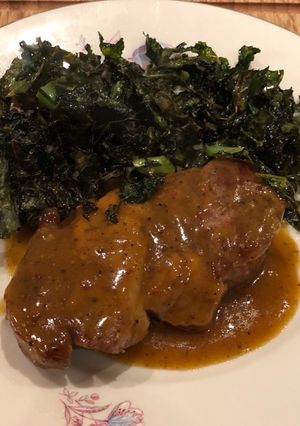 A picture of Greek braised pork with beer, mustard and orange sauce.