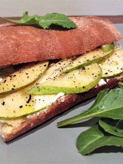 Una foto de Bocata de pan chapata con queso para untar y pera