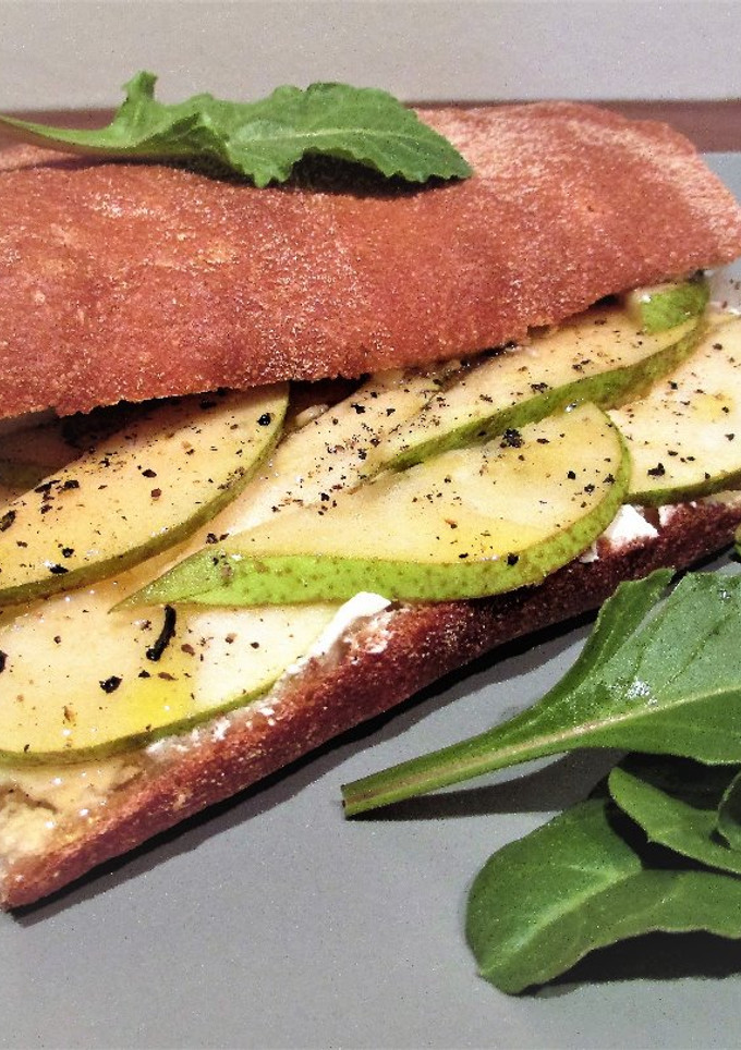 Una foto de Bocata de pan chapata con queso para untar y pera