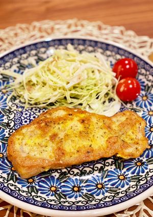 A picture of Curry flavored pork piccata with parmesan.