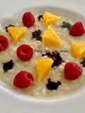 Risotto cremoso, arancia, lamponi, gocce di cioccolato